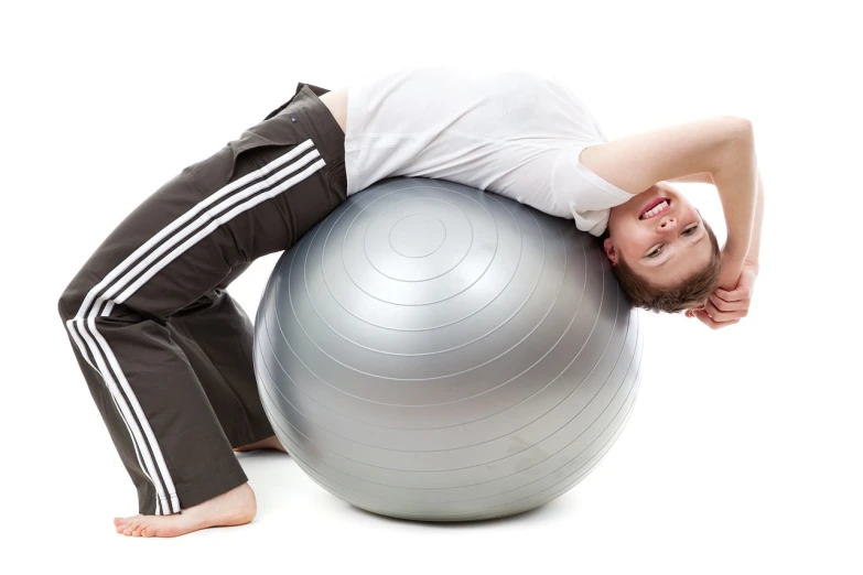 a man laying on top of an exercise ball, a stock photo, by Matija Jama, shutterstock, shiny silver, on a white background, teen boy, big complex belly mechanism