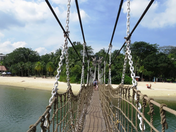 a suspension bridge over a body of water, inspired by Samuel Silva, hurufiyya, monkey island, walking up the sandy beach, interesting details, theme park