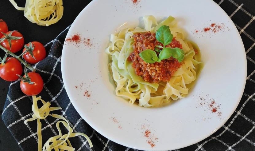 a close up of a plate of food on a table, inspired by Gianfredo Camesi, pexels, noodles, wikimedia commons, ribbon, tomato sauce
