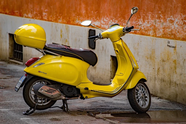 a yellow motor scooter parked in front of a building, a photo, trending on pixabay, marble!! (eos 5ds r, in rich color, it has lemon skin texture, just after rain