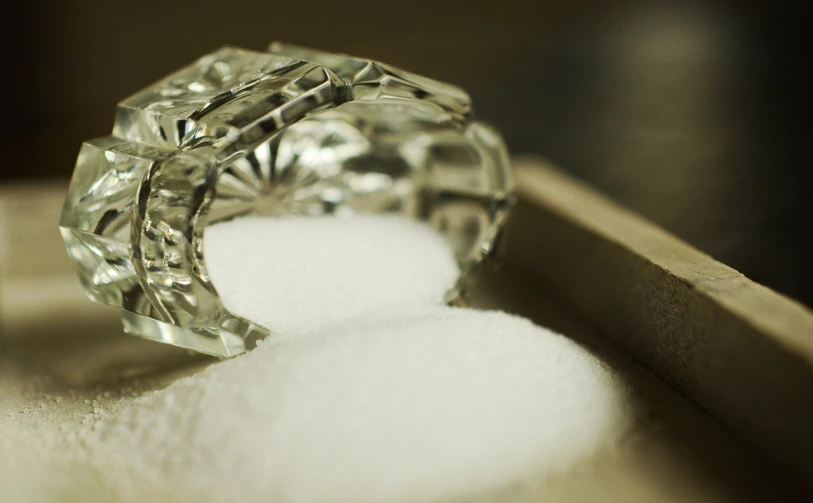 a diamond ring sitting on top of a pile of sugar, a macro photograph, by Sylvia Wishart, flickr, process art, salt shaker, hook as ring, jaquet droz, morning detail