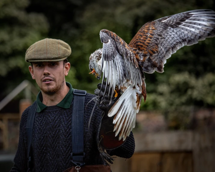 a man holding a hawk on his arm, a portrait, by Robert Brackman, pexels contest winner, performance, wearing a flying jacket, 🦩🪐🐞👩🏻🦳, english