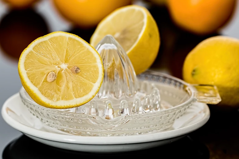 a slice of lemon being squeezed into a juicer, a picture, by Tom Carapic, pixabay, photorealism, crystal, beware the ides of march, oranges, krystal