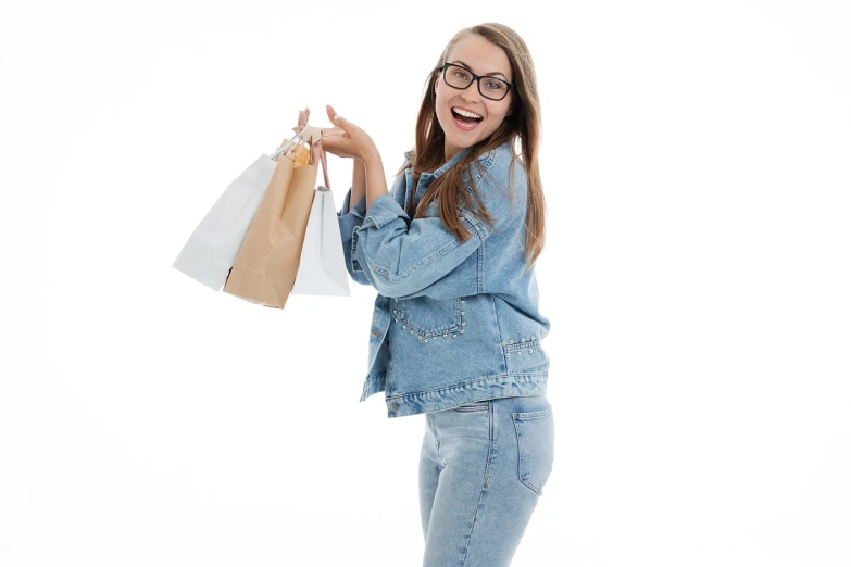 a woman with shopping bags on a white background, a picture, by Aleksander Gierymski, shutterstock, wearing a jeans jackets, girl creates something great, slight nerdy smile, high quality product photo