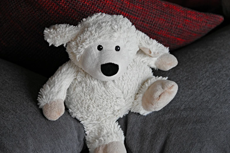 a white teddy bear sitting on top of a couch, a stock photo, inspired by Leo Leuppi, pixabay, lamb and goat fused as one, sigma 85/1.2 portrait, stock photo, stuffed