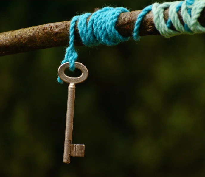 a close up of a rope with a key on it, flickr, symbolism, outside, coloured, amulet, restoration