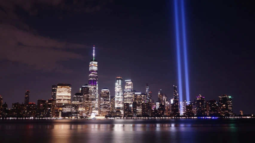 a view of the new york city skyline at night, by Joseph Pisani, pexels, digital art, 9 / 1 1 attacks, beams of light, remembrance, wide establishing shot