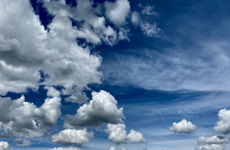 a man flying a kite on top of a lush green field, by Jan Rustem, precisionism, beautiful sky with cumulus couds, panorama view of the sky, shot on iphone 1 3 pro max, very low angle photograph