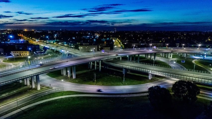 an aerial view of a city at night, a portrait, by Adam Szentpétery, overpass, capital of estonia, high quality photos, blue hour lighting