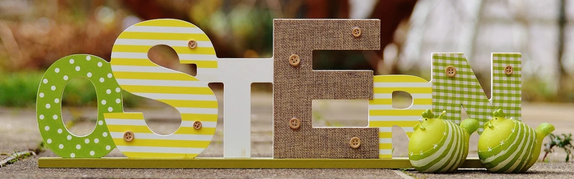 a couple of wooden letters sitting on top of a sidewalk, a picture, flickr, yellow backdrop, shelf, easter, woven with electricity