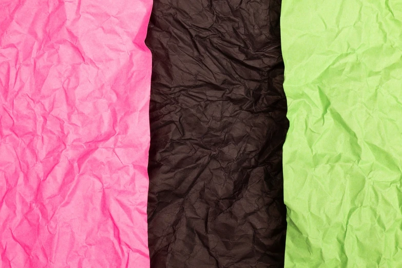 three different colors of crumpled paper on top of each other, color field, neon pink and black color scheme, textured parchment background, green and brown clothes, close up photo
