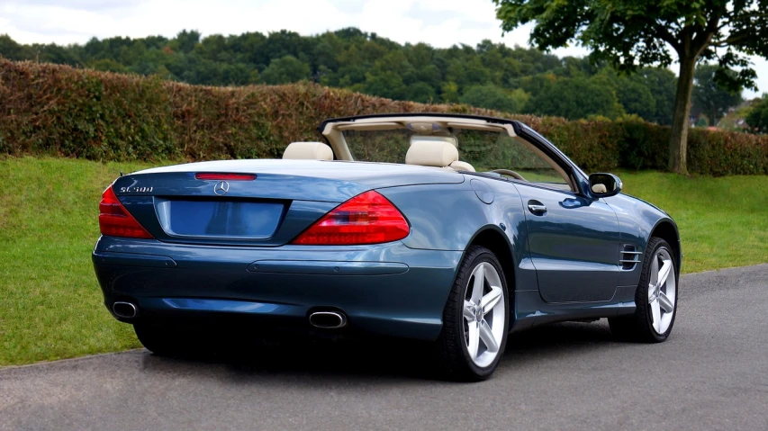 a blue convertible parked on the side of a road, mercedez benz, superior detail, esher, back