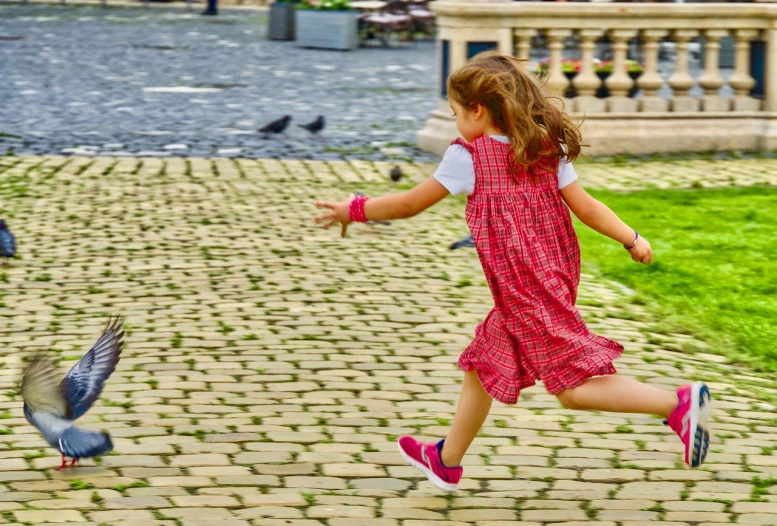 a little girl that is jumping in the air, a picture, inspired by Ruth Orkin, shutterstock, naive art, cobblestone roads, romanian, the anime girl is running, high resolution photo