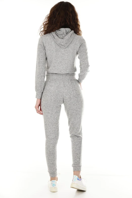 a woman standing with her back to the camera, wearing a hoodie and sweatpants, full product shot, fullbodysuit, catalog photo