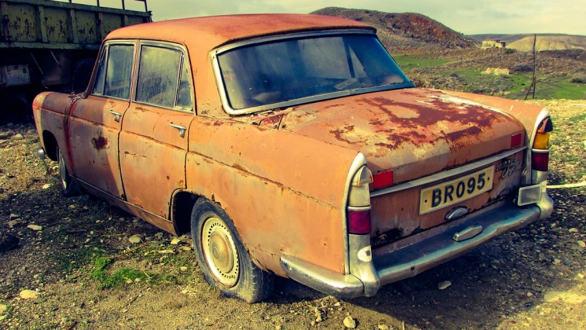 an old rusted out car sitting in a field, trending on pixabay, auto-destructive art, brushed rose gold car paint, moskvich, rear facing, high definition screenshot