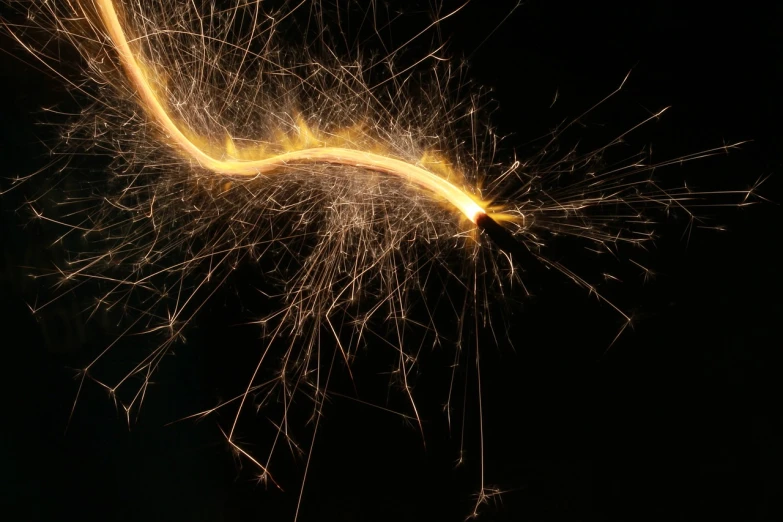 a close up of a sparkler on a black background, a microscopic photo, digital art, golden curve composition, high res photo, thin wires, some chaotic sparkles