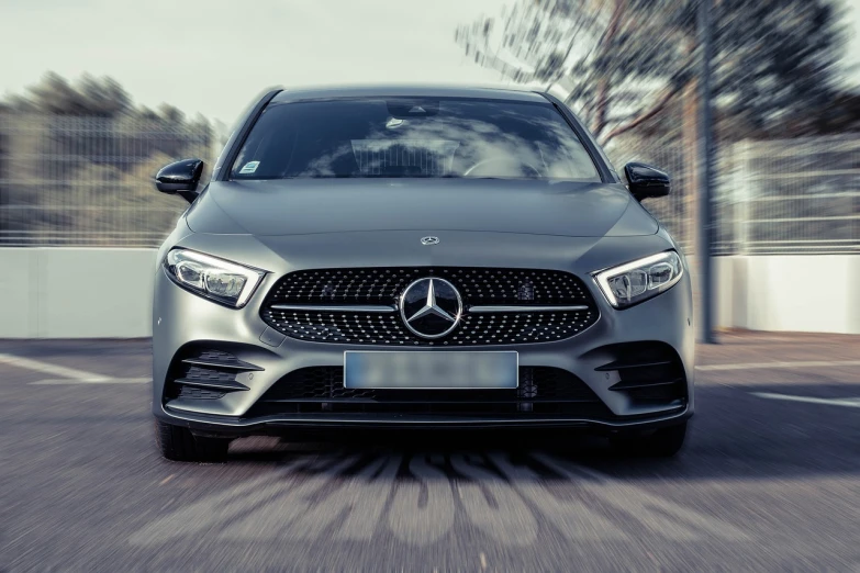 a close up of a car driving on a road, a picture, shutterstock, realism, mercedez benz, front face asymmetrical, advertising photo, gun metal grey