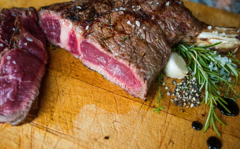 a piece of steak sitting on top of a wooden cutting board, by Richard Carline, food photography gourmet, food blog photo, slice of life, tyler west