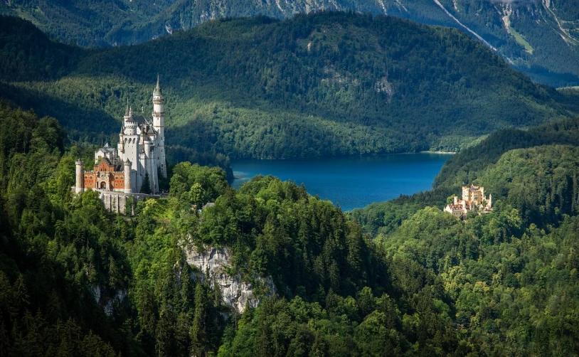 a castle sitting on top of a lush green hillside, a detailed matte painting, by Werner Gutzeit, shutterstock, forest with lake, seen from above, munich, peak experience ”