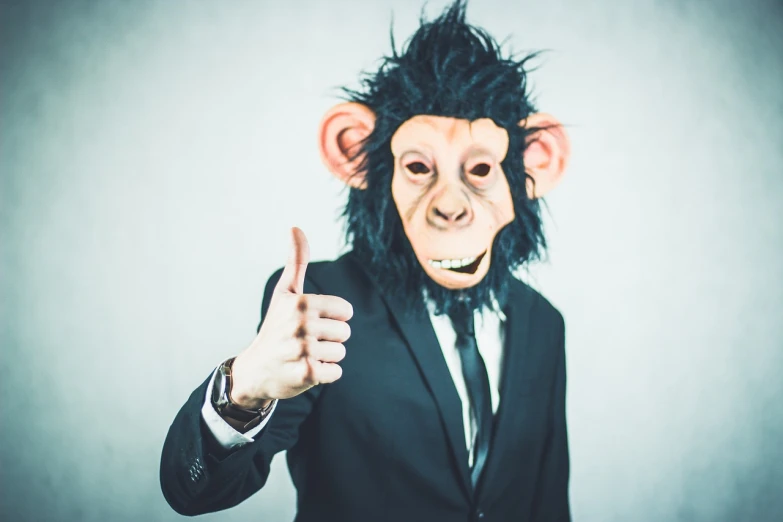 a man wearing a monkey mask giving a thumbs up, a stock photo, by Emma Andijewska, shutterstock, bauhaus, wearing black business suit, high quality fantasy stock photo, chimpanzee, using dead lion costume jacket