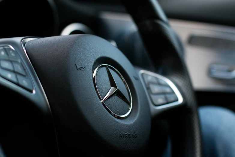a close up of a steering wheel in a car, a picture, by Tom Carapic, pixabay, mercedez benz, silver insignia, matte sharp focus, 3 dimensional