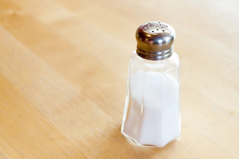 a salt shaker sitting on top of a wooden table, a picture, by Susan Weil, shutterstock, glazed, close-up product photo, stock photo, sunken
