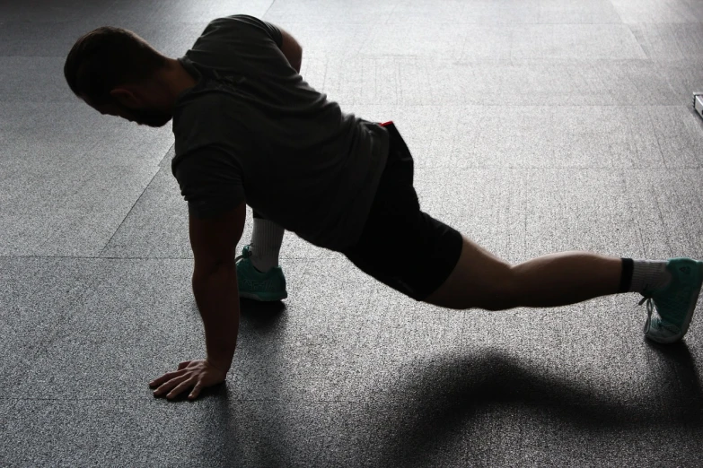 a man doing push ups in a gym, pixabay, dynamic shadow, lizard pose, leg, 30 year old man :: athletic