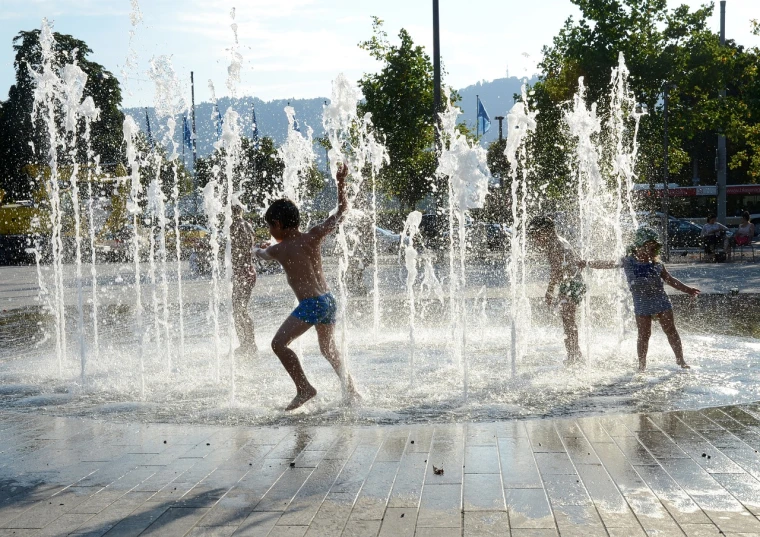 a couple of kids playing in a fountain, figuration libre, summer morning, nice weather, taken on a 2010s camera, waterscape