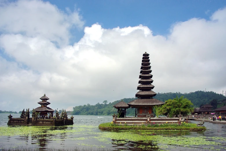 a group of pagodas sitting on top of a body of water, a picture, inspired by I Ketut Soki, flickr, bali, ceremonial clouds, lakeside, 3 0 0