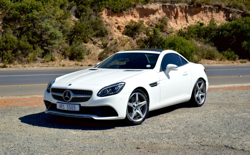 a white sports car parked on the side of the road, a picture, by Alexander Brook, mercedez benz, cape, front side views full, full res