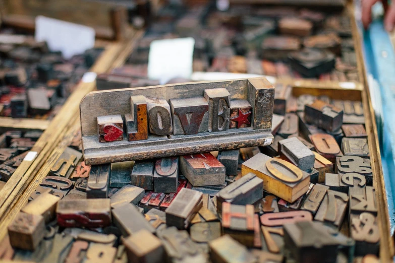 a pile of old letterpresss sitting on top of a table, letterism, love theme, market, dwell, made of wood