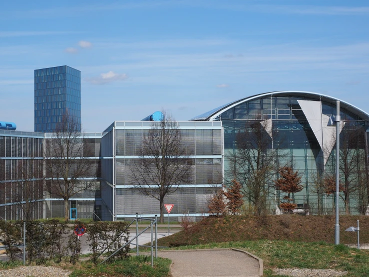 a couple of buildings that are next to each other, a picture, inspired by Robert Zünd, flickr, laboratory in the background, huge glass structure, slightly sunny weather, hcl