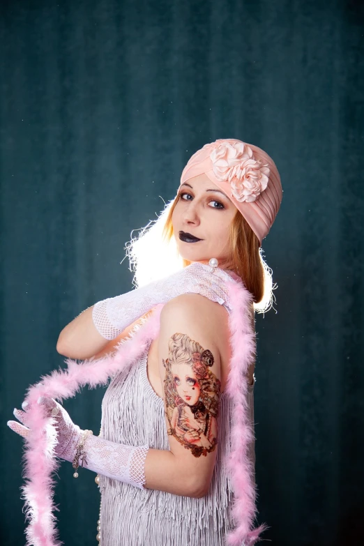 a woman with a tattoo on her arm, a portrait, inspired by George barbier, flickr, pink studio lighting, roaring twenties, cosplay photo, taken in the early 2020s