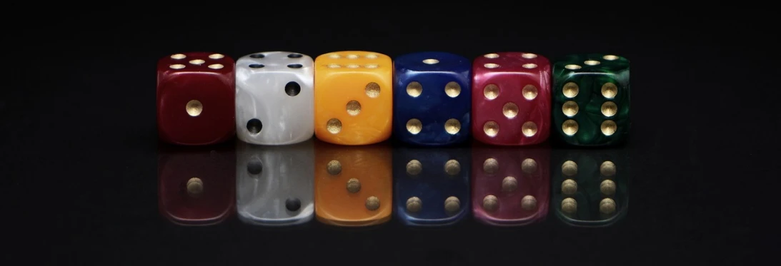 a row of dice sitting on top of a table, by Rhea Carmi, pixabay, in front of a black background, four, portrait of a big, colored marble