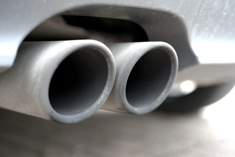 a close up of a car exhaust pipe, shutterstock, photograph credit: ap, with pipes attached to it, graphite, twins