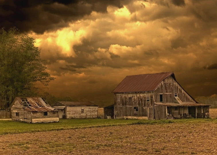 a barn sitting in the middle of a field under a cloudy sky, a picture, by Robert Storm Petersen, shutterstock, renaissance, burnt huts, dramatic golden light, dark and beige atmosphere, southern gothic scene