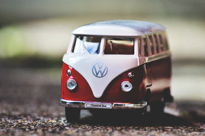 a toy vw bus is sitting on the ground, unsplash, photorealism, red brown and white color scheme, closeup - view, phone wallpaper, avatar image