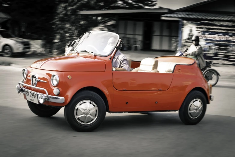 a small red car driving down a street, a digital rendering, inspired by Francesco Filippini, classic portrait, orange tint, soft top, slide show