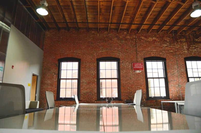 a room that has a table and chairs in it, by John Murdoch, pexels, light and space, brick building, cool marketing photo, red trusses, in the office