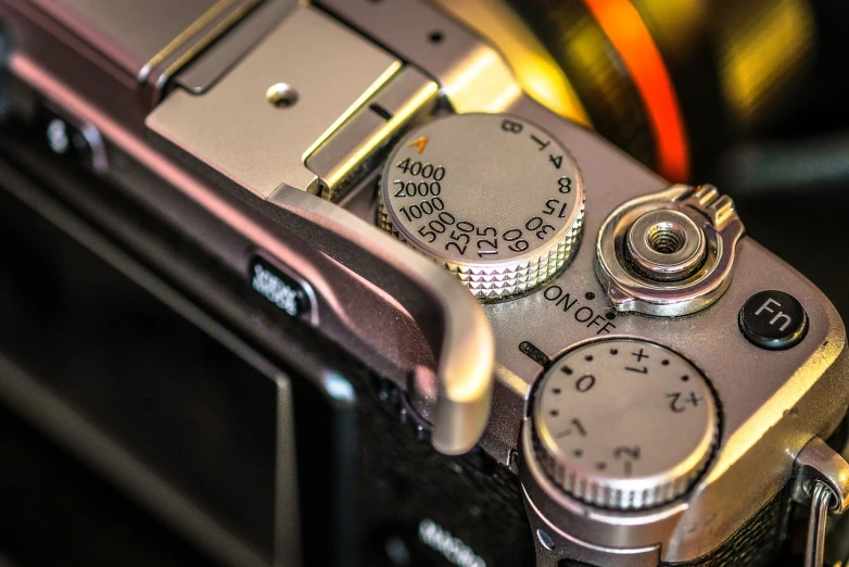 a silver camera sitting on top of a table, a macro photograph, by Jason Felix, ((sharp focus)), dials, detailed 4 k photo, post-processing. high detail