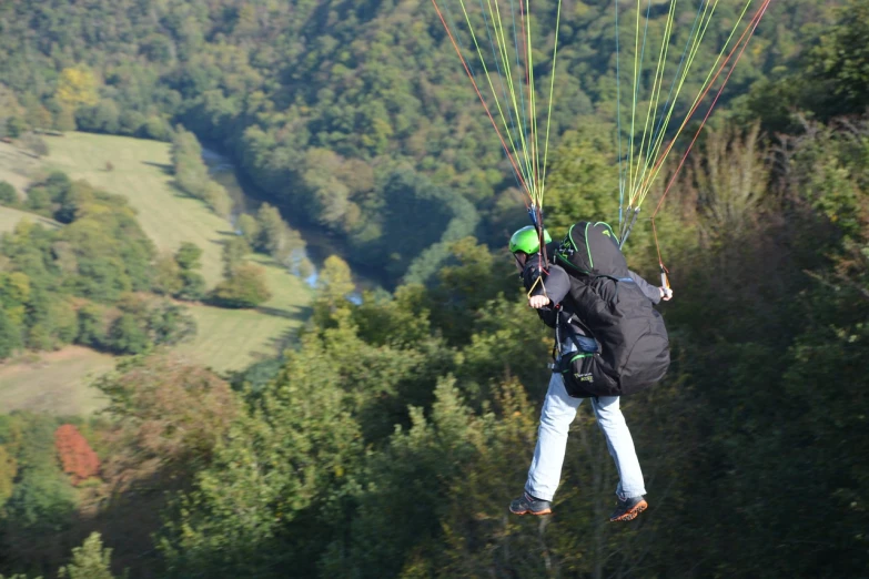 a man flying through the air while holding onto a parachute, a picture, by Erwin Bowien, shutterstock, over the hills, back towards camera, canopy, high walls