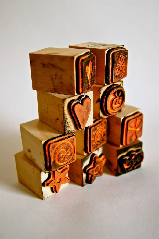 a stack of wooden blocks sitting on top of each other, a woodcut, inspired by Josef Block, flickr, folk art, amber, postage, detailed carved ornaments, heart