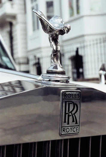 the hood ornament of a rolls royce car, a raytraced image, unsplash, taken with kodak portra, in london, wearing! robes!! of silver, hq ”