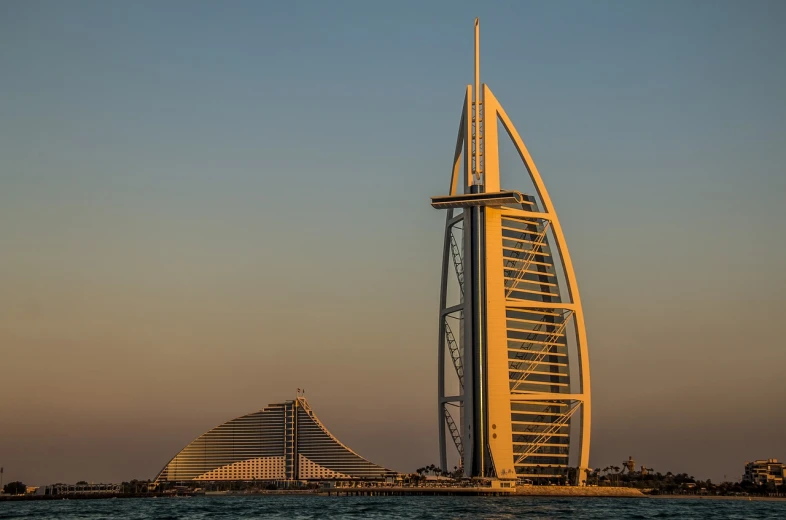 a tall building sitting on top of a body of water, a picture, by Edmund Greacen, pexels contest winner, hurufiyya, sails, tall arches, gulf, megastructure