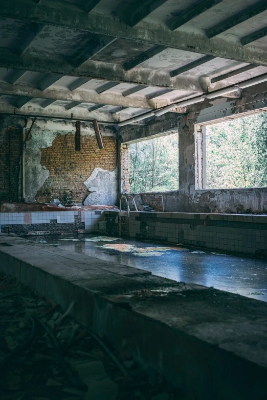 an empty swimming pool in a run down building, inspired by Elsa Bleda, unsplash contest winner, process art, old kitchen backdrop angled view, post apocalyptic ancient ruins, typical russian atmosphere, falling water