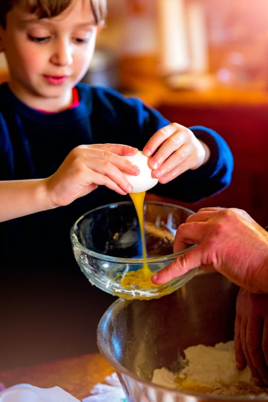 a little boy that is pouring something into a bowl, a stock photo, by Etienne Delessert, pexels, egg yolk, hand made, dad, professionally post-processed