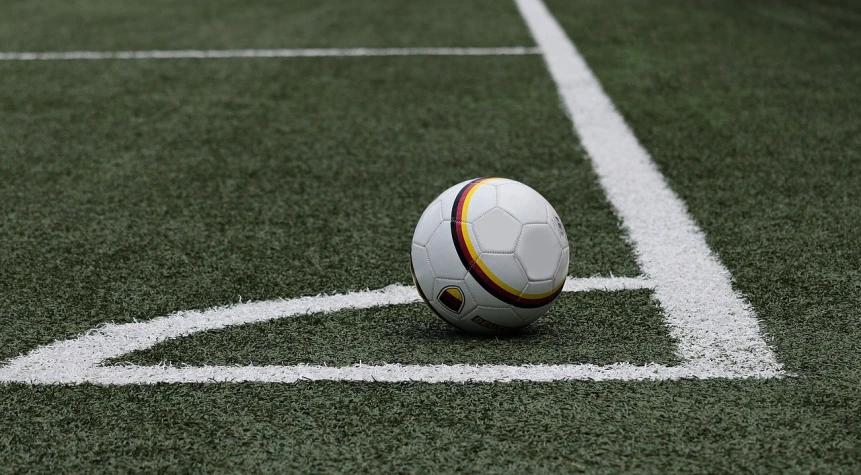 a soccer ball sitting on top of a soccer field, looking partly to the left, soft surfaces, wikimedia commons, avatar image