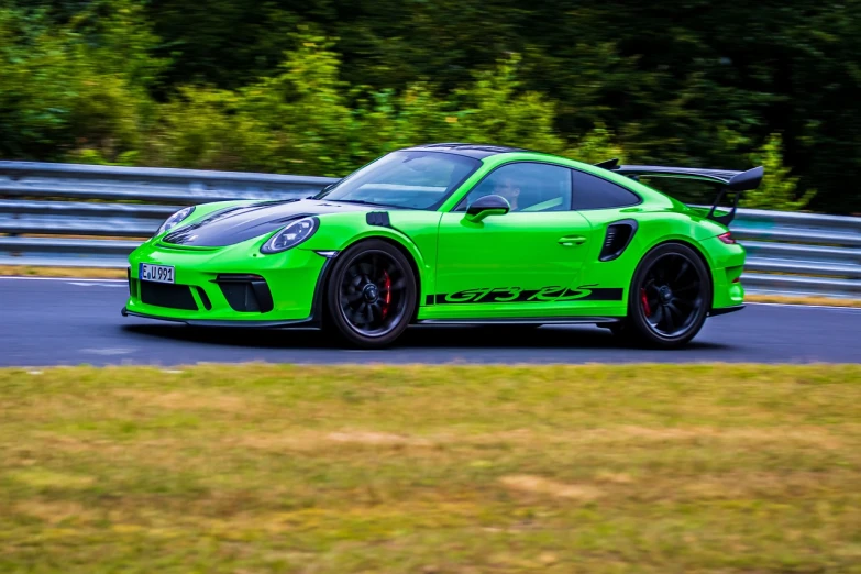 a green sports car driving on a race track, by Zoran Mušič, pexels contest winner, panorama, porche, 🕹️ 😎 🔫 🤖 🚬, side angle