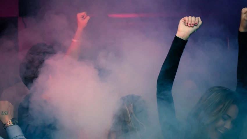 a group of people raising their hands in the air, by Amelia Peláez, pexels, police sirens in smoke, raver girl, severus snape dances in a bar, pink mist