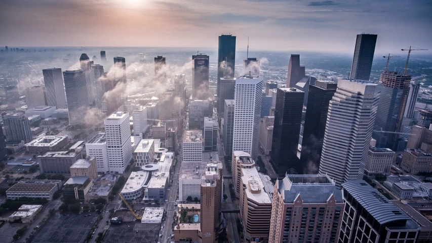 a view of a city with a lot of tall buildings, by Brad Holland, pexels contest winner, louisiana, mist below buildings, drone footage, ice city in 2 0 8 0